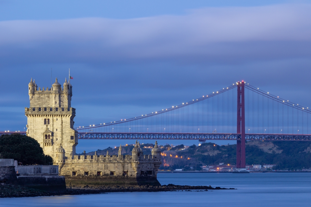 Illuminated,Belem,Tower,,25th,Of,April,Suspension,Bridge,And,Tagus