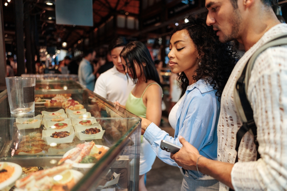 Tourists,Choosing,Street,Food,From,The,Display,Of,A,Stall